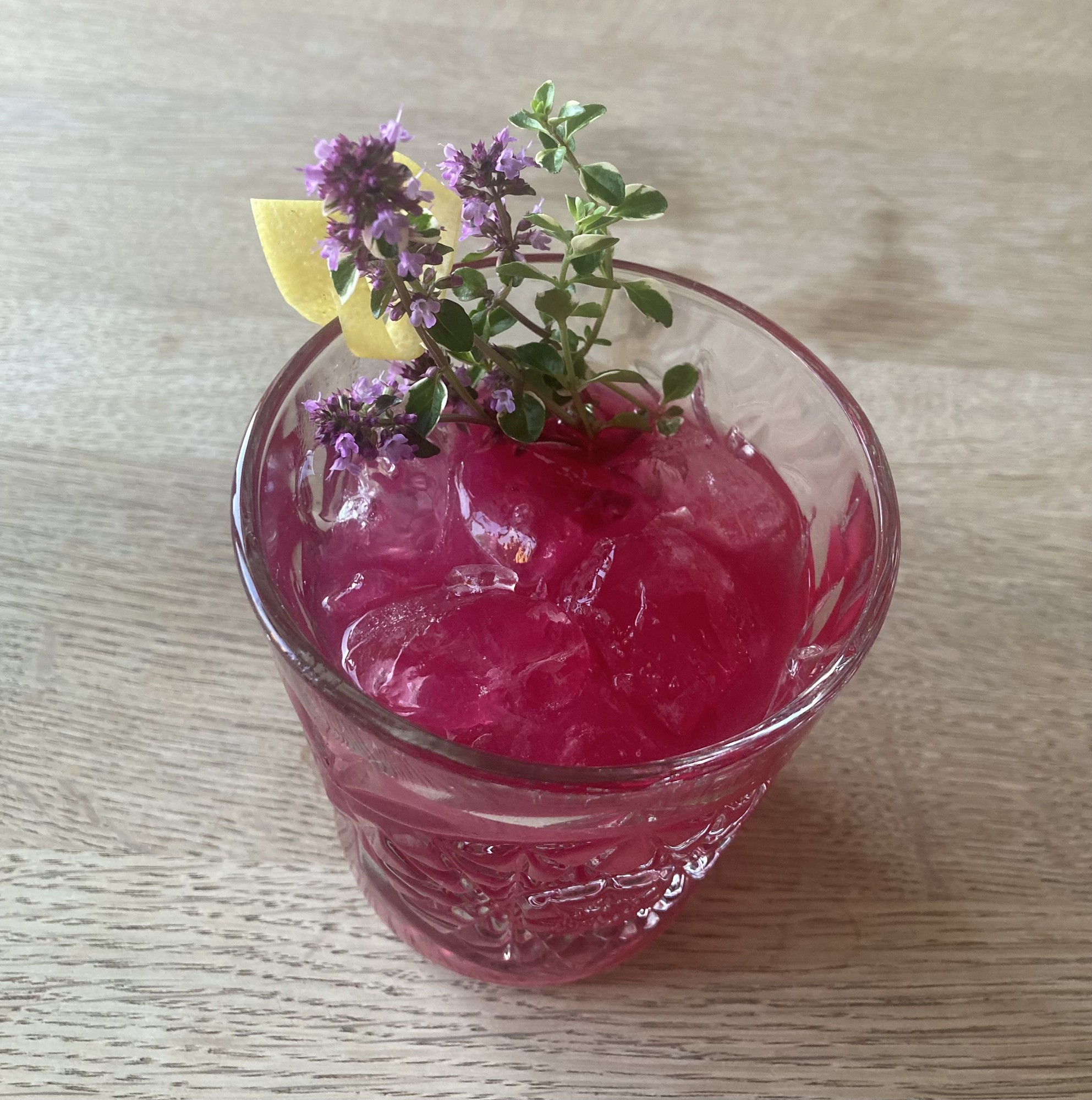 A purple whisky cocktail with herbs