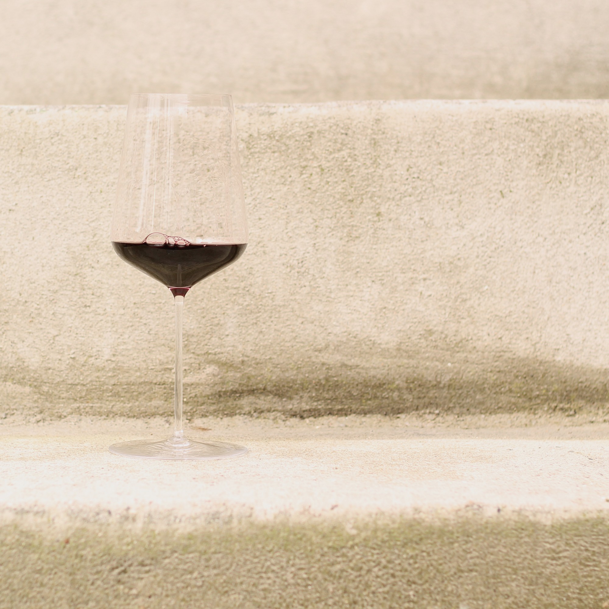 A glass of red wine on stone steps